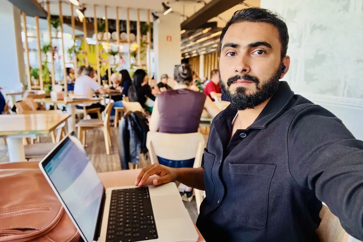 Samama Tahir working on a laptop in a busy café